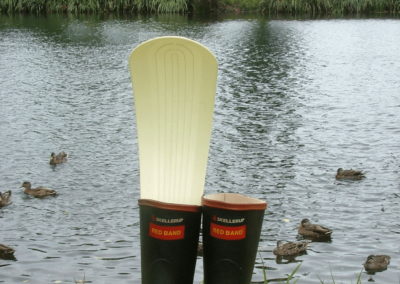 Gumboots fitted with a Windry gumboot drier, in front of a lake